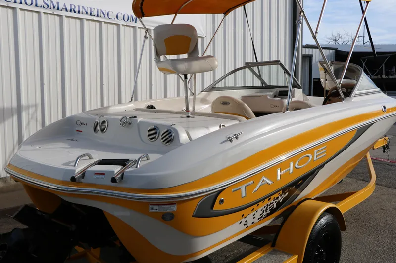 Slide: The Image of 2010 Tahoe Q5i SF boat with yellow accents, parked near a marine facility. - 6