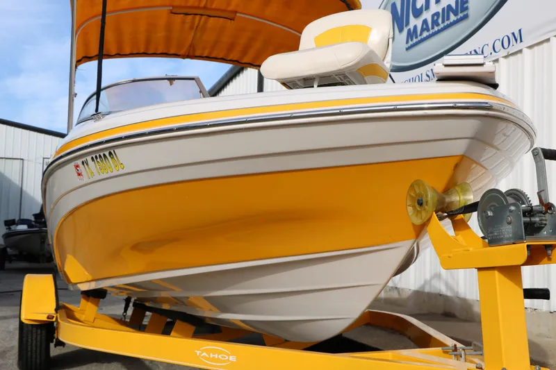Slide: The Image of Yellow 2010 Tahoe Q5i SF boat on trailer, parked near marine building. - 7