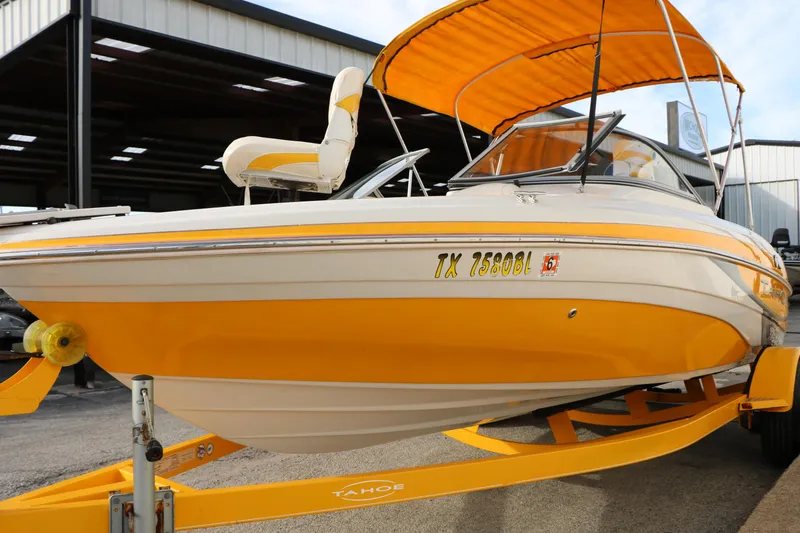 Slide: The Image of 2010 Tahoe Q5i SF boat with yellow accents and canopy on trailer. - 8
