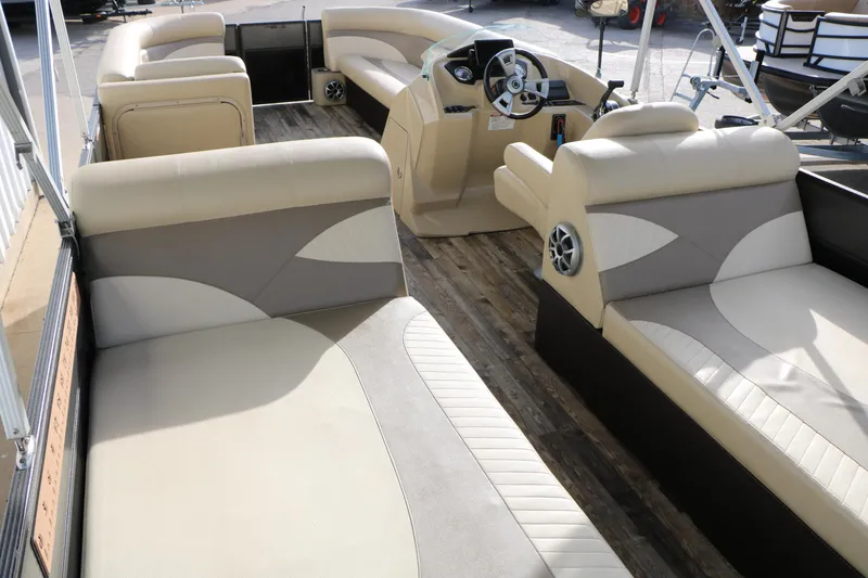 Slide: The Image of 2016 Crest II 250 pontoon boat interior with beige seating and wood flooring. - 10