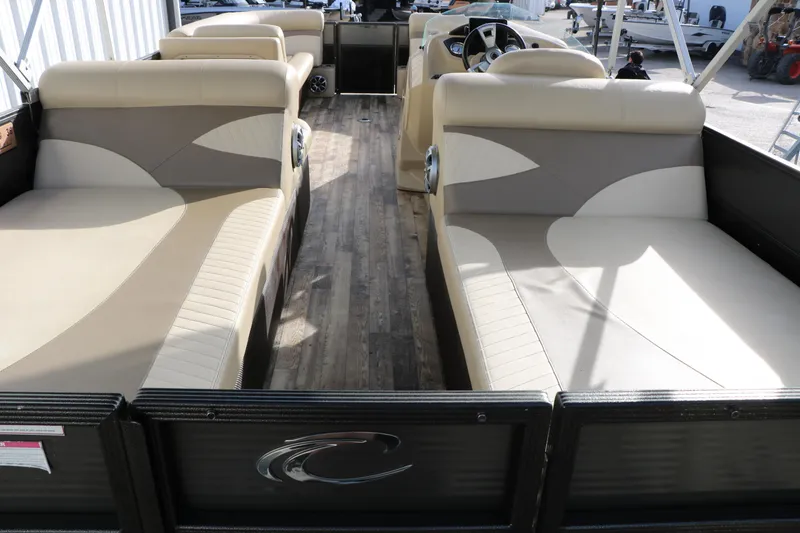 Slide: The Image of 2016 Crest II 250 pontoon boat interior with beige seating and wood flooring. - 12