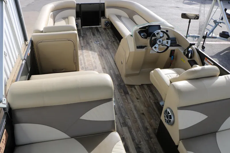 Slide: The Image of 2016 Crest II 250 pontoon boat interior with beige seating and wood-style flooring. - 14