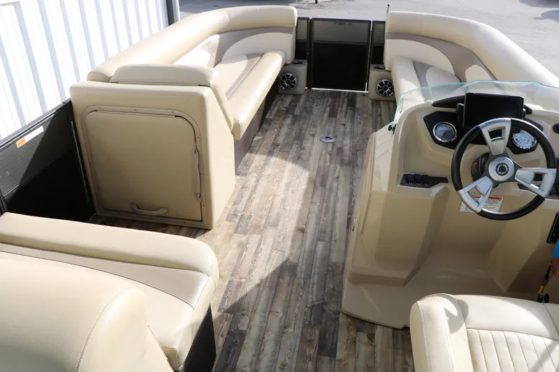 Slide: The Image of 2016 Crest II 250 pontoon boat interior with beige seating and wood-style flooring. - 16