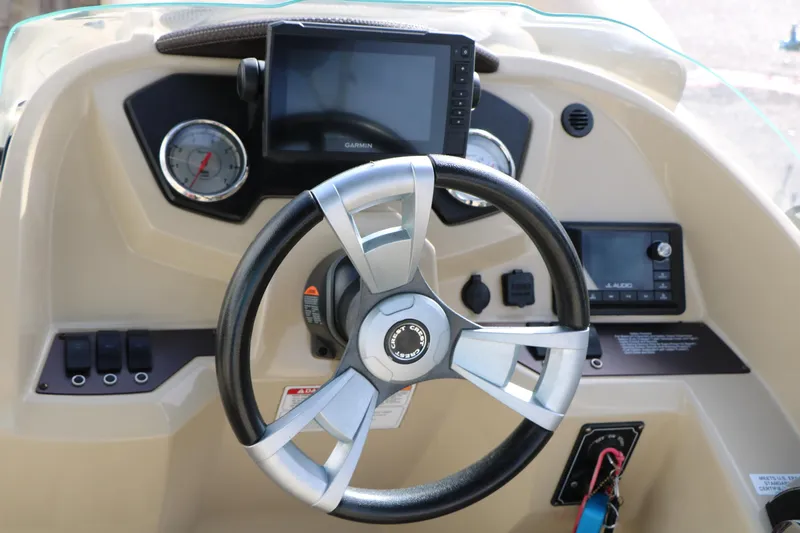 Slide: The Image of Steering console of 2016 Crest II 250 boat with Garmin display and audio controls. - 19