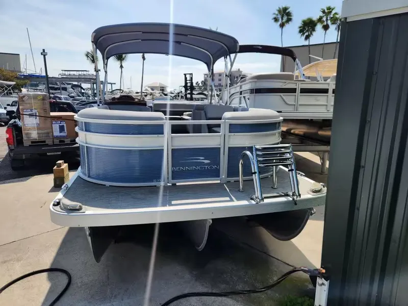 Slide: The Image of 2023 Bennington 22SXL pontoon boat parked at marina. - 4