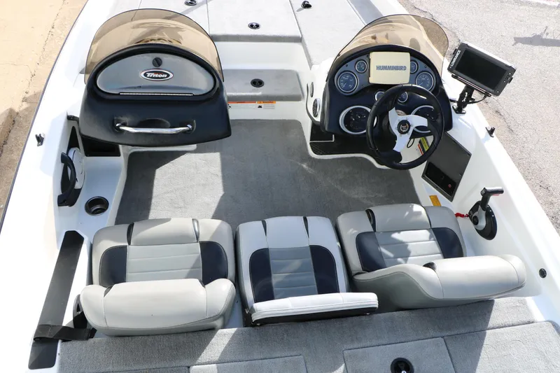 Slide: The Image of 2009 Triton 18 Explorer boat interior with steering console and seating. - 10