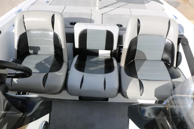Slide: The Image of 2009 Triton 18 Explorer boat interior with three black and gray seats. - 18