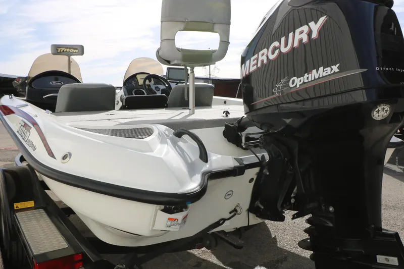 Slide: The Image of 2009 Triton 18 Explorer boat with Mercury OptiMax engine, parked on a trailer. - 23