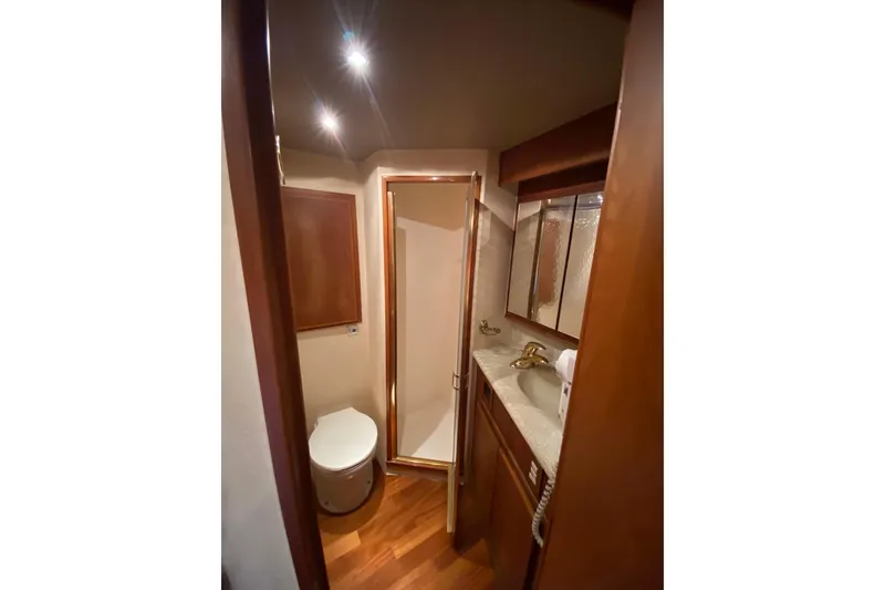 Slide: The Image of Luxurious bathroom in 2001 Egg Harbor 37 Convertible yacht with wood accents and modern fixtures. - 18