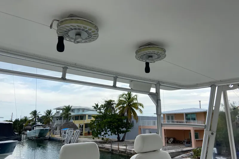 Slide: The Image of 2001 Egg Harbor 37 Convertible boat interior with fishing reels, dockside view. - 55