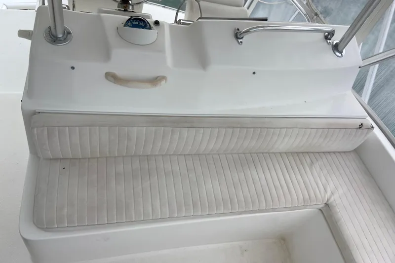 Slide: The Image of 2001 Egg Harbor 37 Convertible boat interior with white cushioned seating and helm controls. - 59
