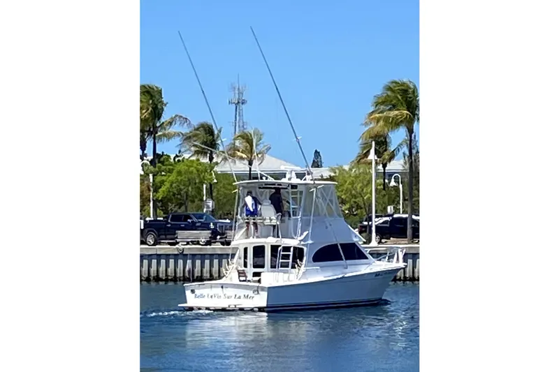 Slide: The Image of 2001 Egg Harbor 37 Convertible yacht cruising near a scenic waterfront with palm trees. - 69