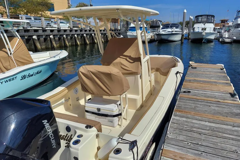 Slide: The Image of 2020 Scout 215 XSF boat docked, featuring Mercury engine and covered seating. - 3