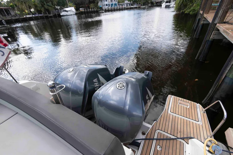 Slide: The Image of 2019 Jeanneau Leader 10.5 with Yamaha outboard engines docked by a serene waterfront. - 15