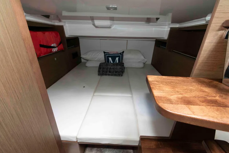 Slide: The Image of 2019 Jeanneau Leader 10.5 cabin interior with bed, pillows, and wooden accents. - 19