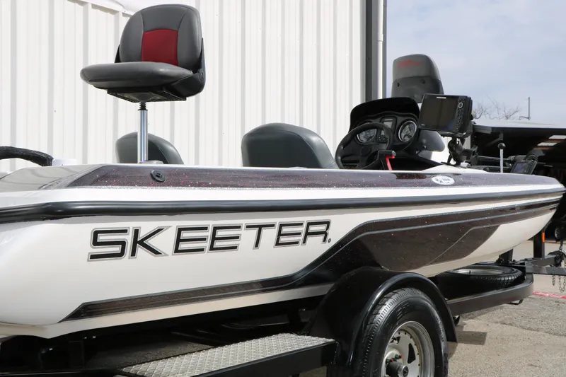 Slide: The Image of 2007 Skeeter SX180 boat with seating and control panel, parked outdoors. - 5