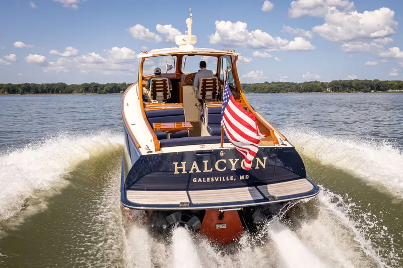 The Image of 2013 Hinckley Talaria 34 boat cruising on water with American flag. - 0