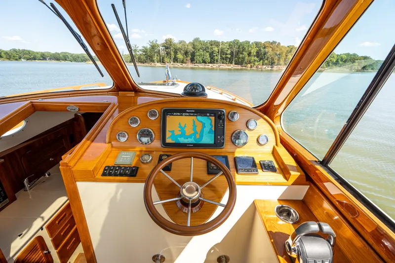 Slide: The Image of Helm of 2013 Hinckley Talaria 34 boat with navigation system and wooden dashboard. - 11