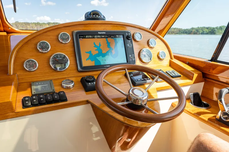 Slide: The Image of Helm of 2013 Hinckley Talaria 34 with navigation system and wooden steering wheel. - 12