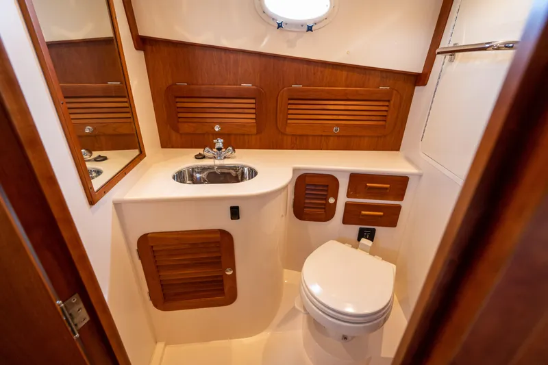 Slide: The Image of 2013 Hinckley Talaria 34 yacht bathroom with wooden cabinetry and stainless steel sink. - 16