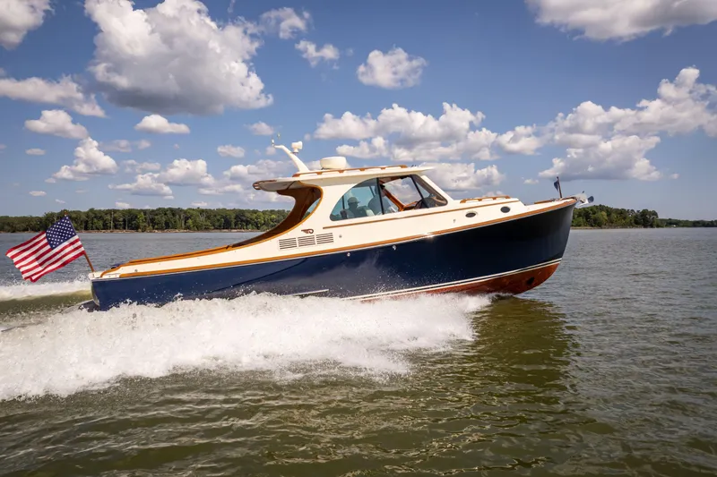 Slide: The Image of 2013 Hinckley Talaria 34 cruising on a lake under a partly cloudy sky. - 2