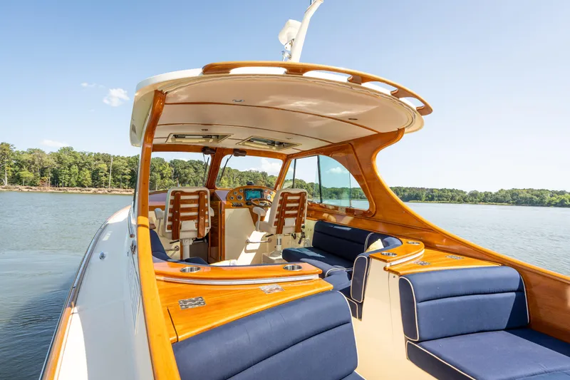 Slide: The Image of 2013 Hinckley Talaria 34 yacht with elegant wood and blue seating on a serene lake. - 7