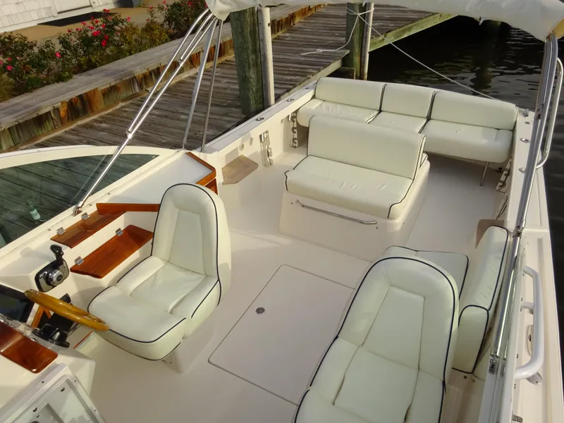 Slide: The Image of 2008 Hunt Yachts Harrier 25 with white seating, docked by wooden pier. - 1