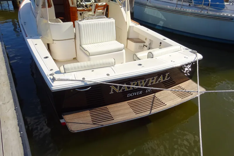 Slide: The Image of 2007 Hunt Yachts Surfhunter 29 docked, featuring elegant seating and wooden deck. - 11