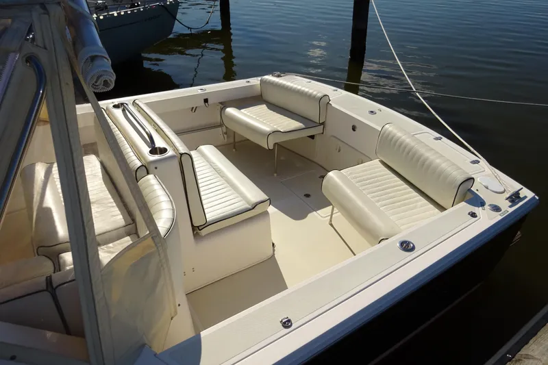 Slide: The Image of 2007 Hunt Yachts Surfhunter 29 boat interior with white seating, docked on calm water. - 14