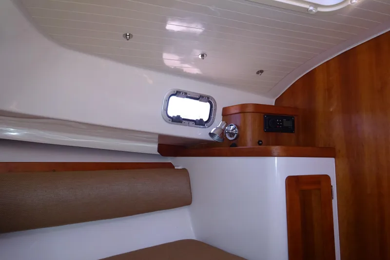 Slide: The Image of Interior of 2007 Hunt Yachts Surfhunter 29 with wood paneling and porthole window. - 47