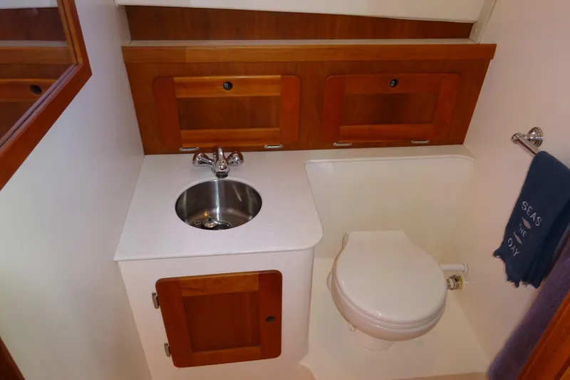 Slide: The Image of 2007 Hunt Yachts Surfhunter 29 bathroom with sink, toilet, and wooden cabinetry. - 49