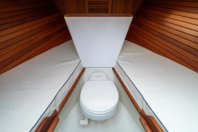 Slide: The Image of 2006 Hinckley Talaria 29 R interior with wooden paneling and compact toilet. - 14