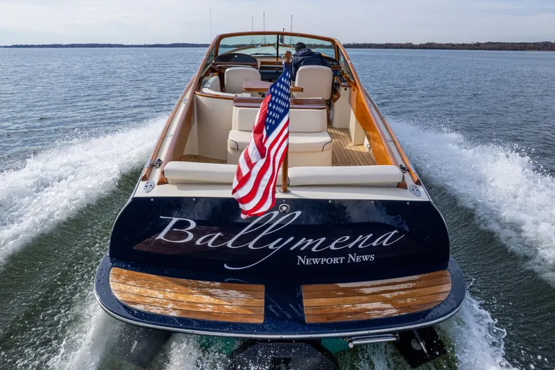 Slide: The Image of 2006 Hinckley Talaria 29 R boat cruising with American flag on water. - 3