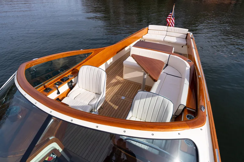 Slide: The Image of 2006 Hinckley Talaria 29 R boat with elegant seating and wooden accents on calm water. - 5