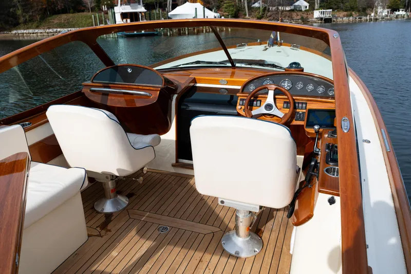 Slide: The Image of 2006 Hinckley Talaria 29 R boat interior with wooden dashboard and white seating. - 7