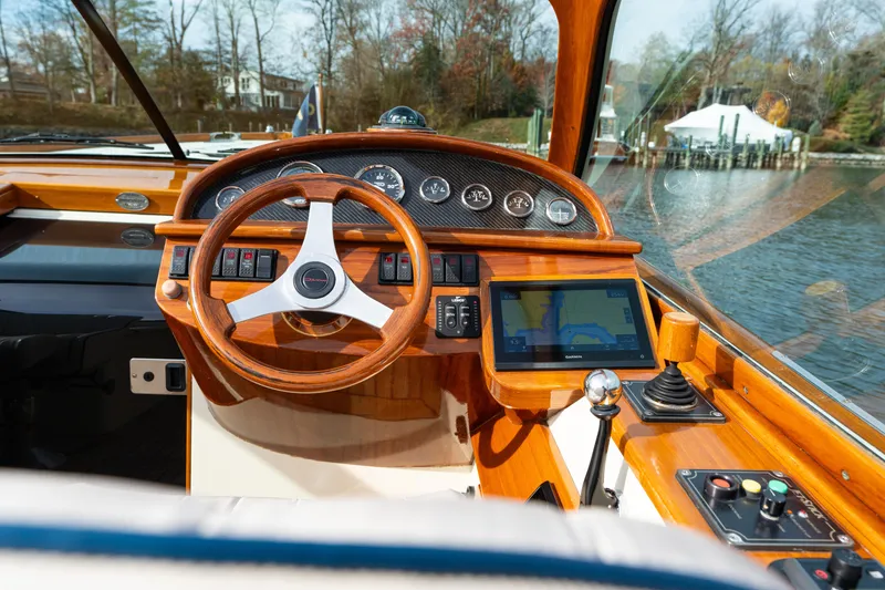 Slide: The Image of 2006 Hinckley Talaria 29 R cockpit with wooden steering wheel and navigation display. - 9