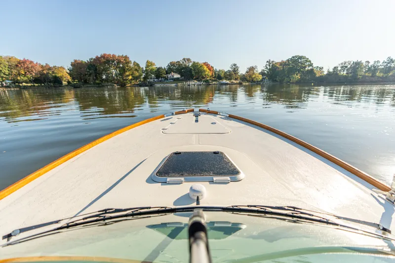 Slide: The Image of Bow view of 2003 Hinckley Talaria 29 Runabout on calm lake with autumn trees. - 15