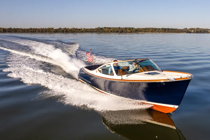 Slide: The Image of 2003 Hinckley Talaria 29 Runabout cruising on a calm lake under clear skies. - 2