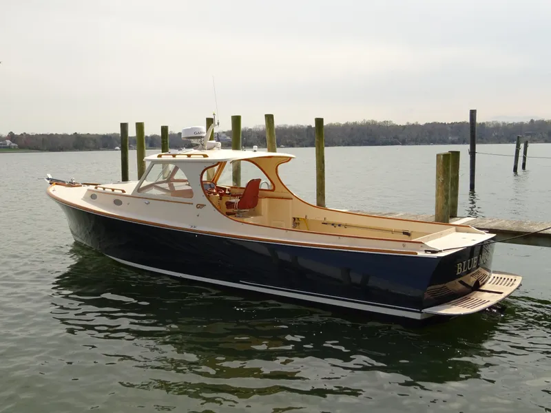 The Image of 1995 Hinckley Picnic Boat Classic docked on calm water. - 0