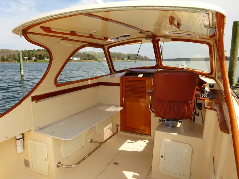 Slide: The Image of 1995 Hinckley Picnic Boat Classic interior with wooden accents and scenic water view. - 15