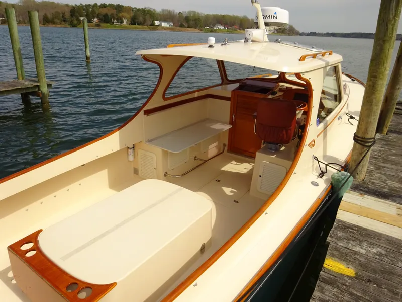Slide: The Image of 1995 Hinckley Picnic Boat Classic docked, showcasing elegant design and spacious deck. - 2