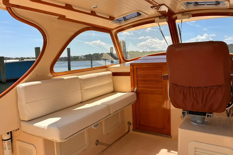 Slide: The Image of Interior of 1995 Hinckley Picnic Boat 36 Classic with beige seating and wooden accents. - 21