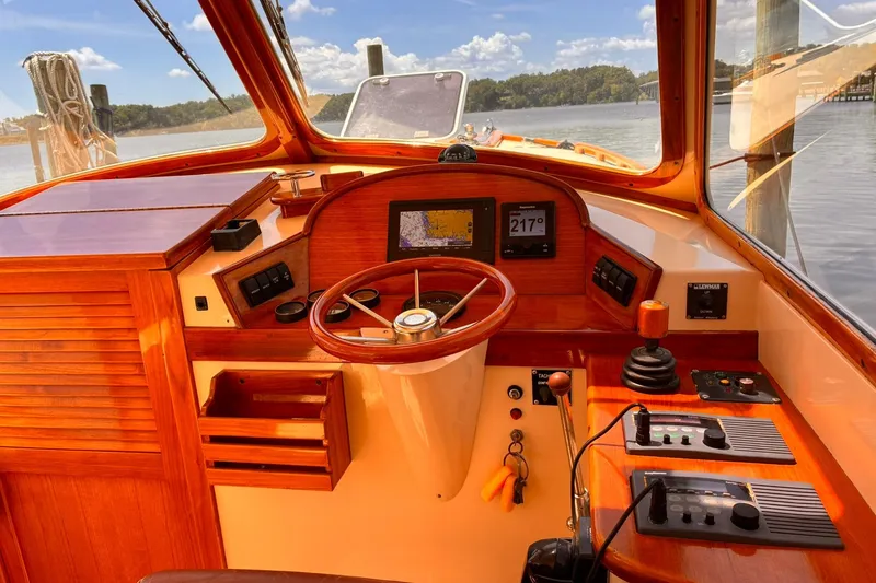 Slide: The Image of Hinckley Picnic Boat 36 Classic 1995 helm with wooden dashboard and navigational instruments. - 23
