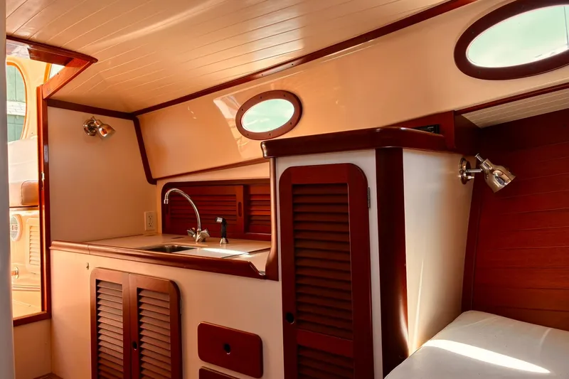 Slide: The Image of Interior of 1995 Hinckley Picnic Boat 36 Classic with wooden cabinetry and porthole windows. - 26
