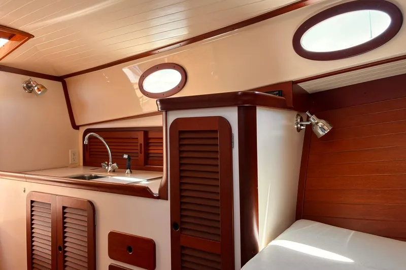 Slide: The Image of Interior of 1995 Hinckley Picnic Boat 36 Classic with wooden cabinetry and compact sink area. - 27