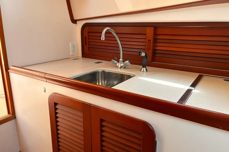 Slide: The Image of Hinckley Picnic Boat 36 Classic 1995 galley with wooden cabinetry and stainless steel sink. - 28