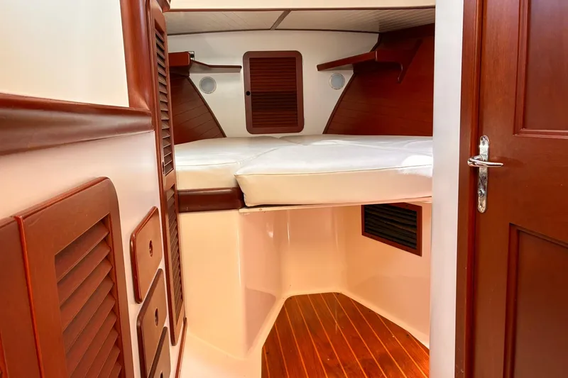 Slide: The Image of Interior cabin of 1995 Hinckley Picnic Boat 36 Classic with wooden accents and white cushions. - 29