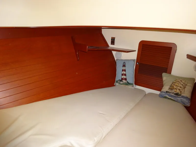 Slide: The Image of Cozy cabin interior of 1995 Hinckley Picnic Boat Classic with nautical-themed pillows. - 31