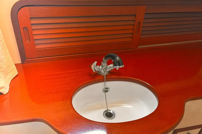 Slide: The Image of Hinckley Picnic Boat 36 Classic 1995 interior sink with wooden countertop and vintage faucet. - 32