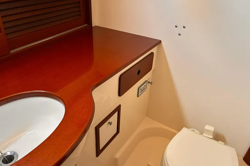 Slide: The Image of Hinckley Picnic Boat 36 Classic 1995 bathroom with wooden countertop and white sink. - 33